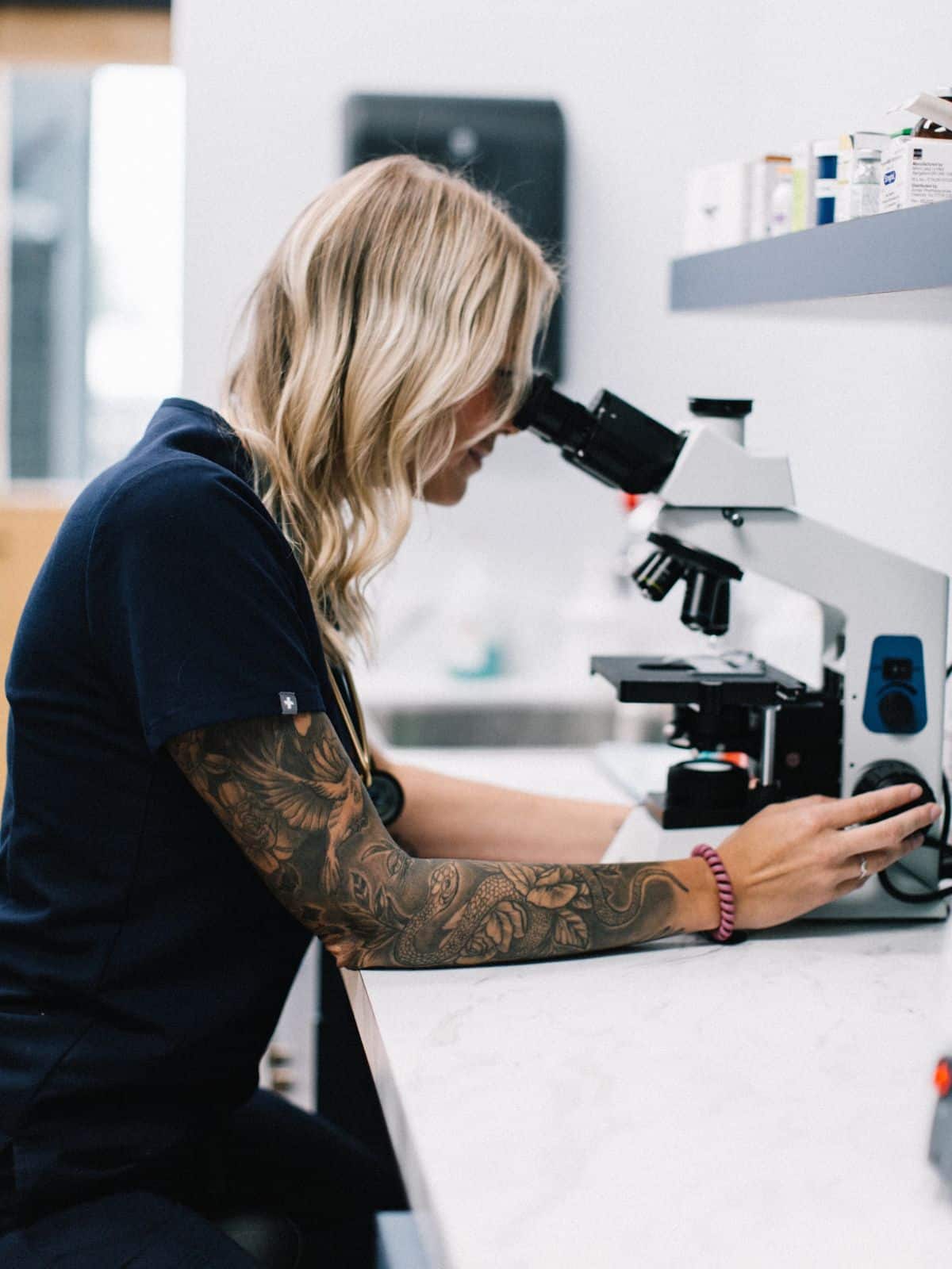 vet staff testing sample through microscope