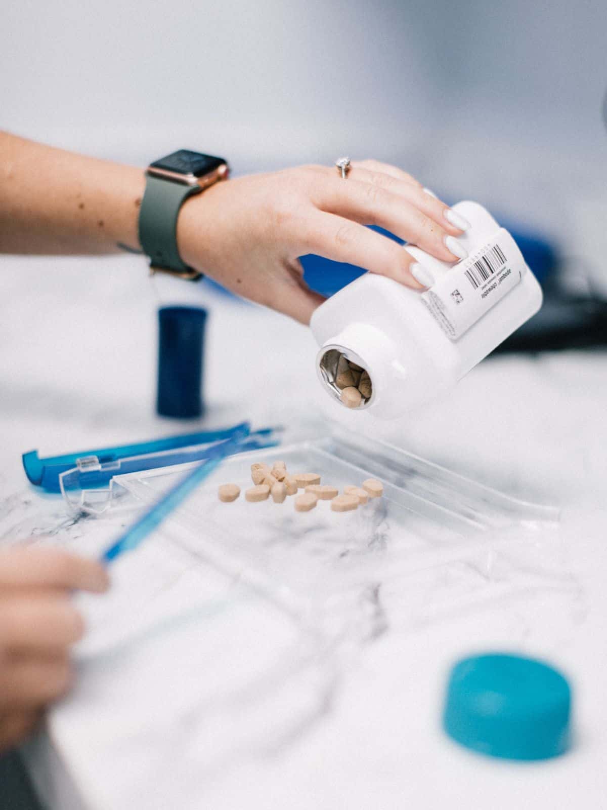 vet staff taking tablets out of a bottle